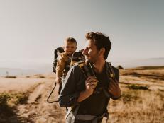 Photo of young father spending time with his son by taking him on a hike while he is in a baby carrier backpack