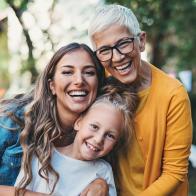 Portrait of happy grandmother, mother and daughter in the back yard