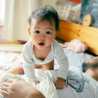 Morning Mood Asian baby wake up early before daddy and playful on the bed