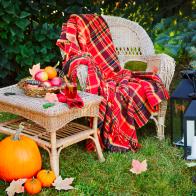 Cup of tea and apples on table and chair in autumn garden