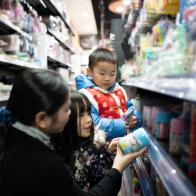Young asian woman shopping in supermarket with two children