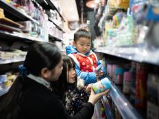 Young asian woman shopping in supermarket with two children