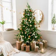 White and spacious domestic living room decorated with Christmas fir tree and pastel holiday decor. Festive craft gift boxes and wrapped presents for family and friends. Cozy celebrations at home