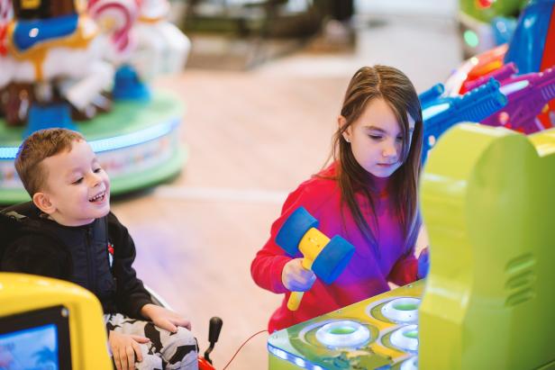 Boy in wheelchair and girl in in amusement arcade