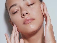 Young sensuality beautiful teen with clean skin with splash of water - blue background