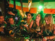 Happy multi-ethnic friends drinking and having fun at Saint Patrick's day night club party