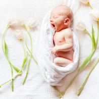 Newborn baby with artistic beautiful flowers.