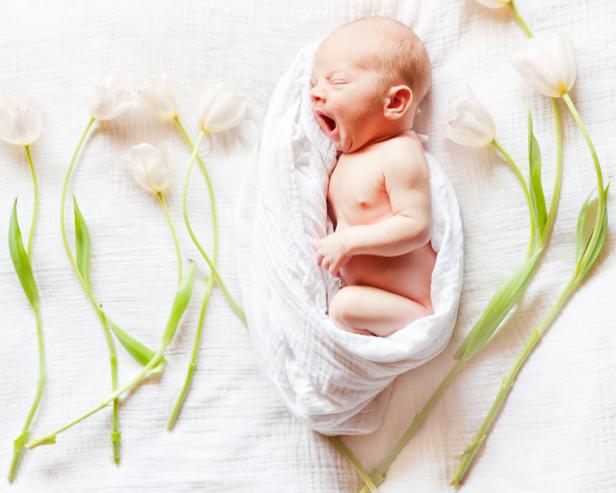 Newborn baby with artistic beautiful flowers.