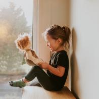 Cute little girl holding a doll.