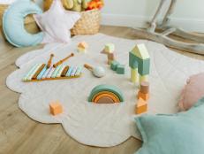 Beautiful decoration nursery with wicker baskets, linen rug, cushions and wooden toys. Perfect spot for playtime. Plastic free. Zero waste and ecological concept.