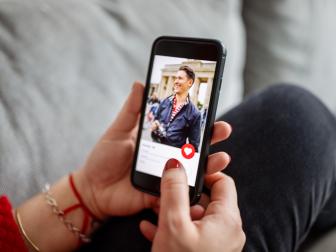 Close-up of a female using a dating app on smart phone. Woman looking at man on an online dating app on her mobile phone.