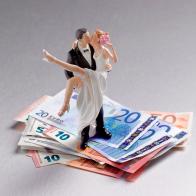Wedding couple figurine standing on a pile of Euros