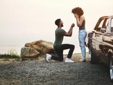 Shot of a young man proposing to his girlfriend during a road trip