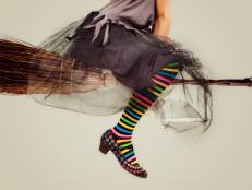 image of a woman dressed like a witch with colorful striped panties and sitting in a flying bloom ,Grey background