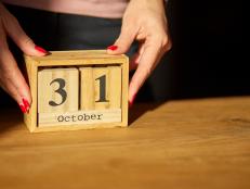 Woman hand change, sets the date on the wooden calendar on 31 October , Thanksgiven day, Halloween, hard light, sunlight,