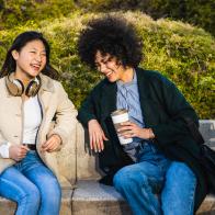 Beautiful asian women joking and spending a relaxing afternoon in the park. Enjoying the nice spring weather outside after work.