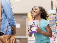 Elementary age girl pleads with her mom to buy her a toy while shopping.