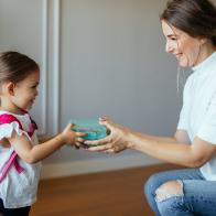 Mother and child packing backpack for the school, getting ready for school