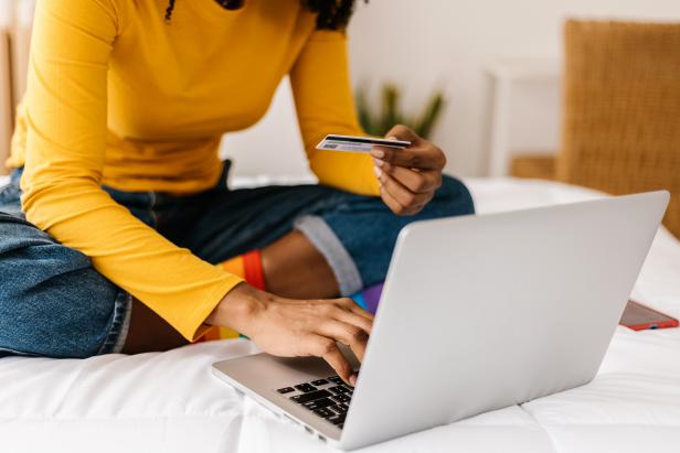 Close up woman hands using credit card to buy online on laptop - E-commerce and shopping online concept