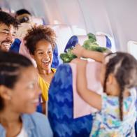 Multiracial family with two children traveling to summer vacation by airplane.
