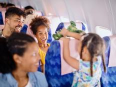 Multiracial family with two children traveling to summer vacation by airplane.