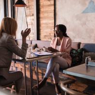 Two business women at the cafe restaurant discussing during coffee break