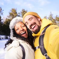 Happy and beautiful interracial young marriage taking a smily selfie in the snow.