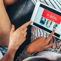 Two female friends drinking coffee and shopping online