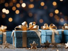 Holiday presents wrapped in teal paper and gold glitter, with a bokeh light backdrop