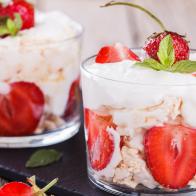 Eton Mess - Strawberries with whipped cream and meringue in a glass beaker. Classic British summer dessert.selective focus