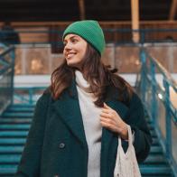 Low angle shot of beautiful woman walking down the stairs, holding ecological shopping bag with groceries. Woman in the city shopping at thrift market. Concept of recycling, upcycling and environmental sustainability.