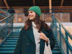 Low angle shot of beautiful woman walking down the stairs, holding ecological shopping bag with groceries. Woman in the city shopping at thrift market. Concept of recycling, upcycling and environmental sustainability.