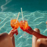 Female friends at a poolside summer party enjoying cocktails