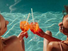 Female friends at a poolside summer party enjoying cocktails