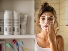 Young woman having daily washing and cleaning skin routine in the bathroom