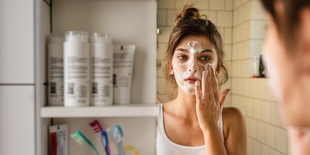 Young woman having daily washing and cleaning skin routine in the bathroom