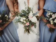 Bride and bridesmaids in blue dresses with bunches of white roses