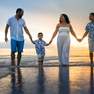 Hispanic family walking on empty beach Florida