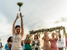 Bride throwing the bouquet to her friends on the beach wedding party