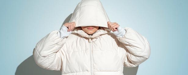 Portrait of teenage girl wearing white hooded jacket and face covered.Studio shot 