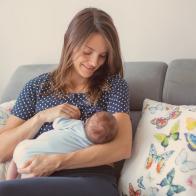 Young mother breastfeeding  her newborn baby boy at home