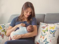 Young mother breastfeeding  her newborn baby boy at home