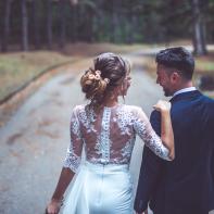 Bride and groom walking through the park together