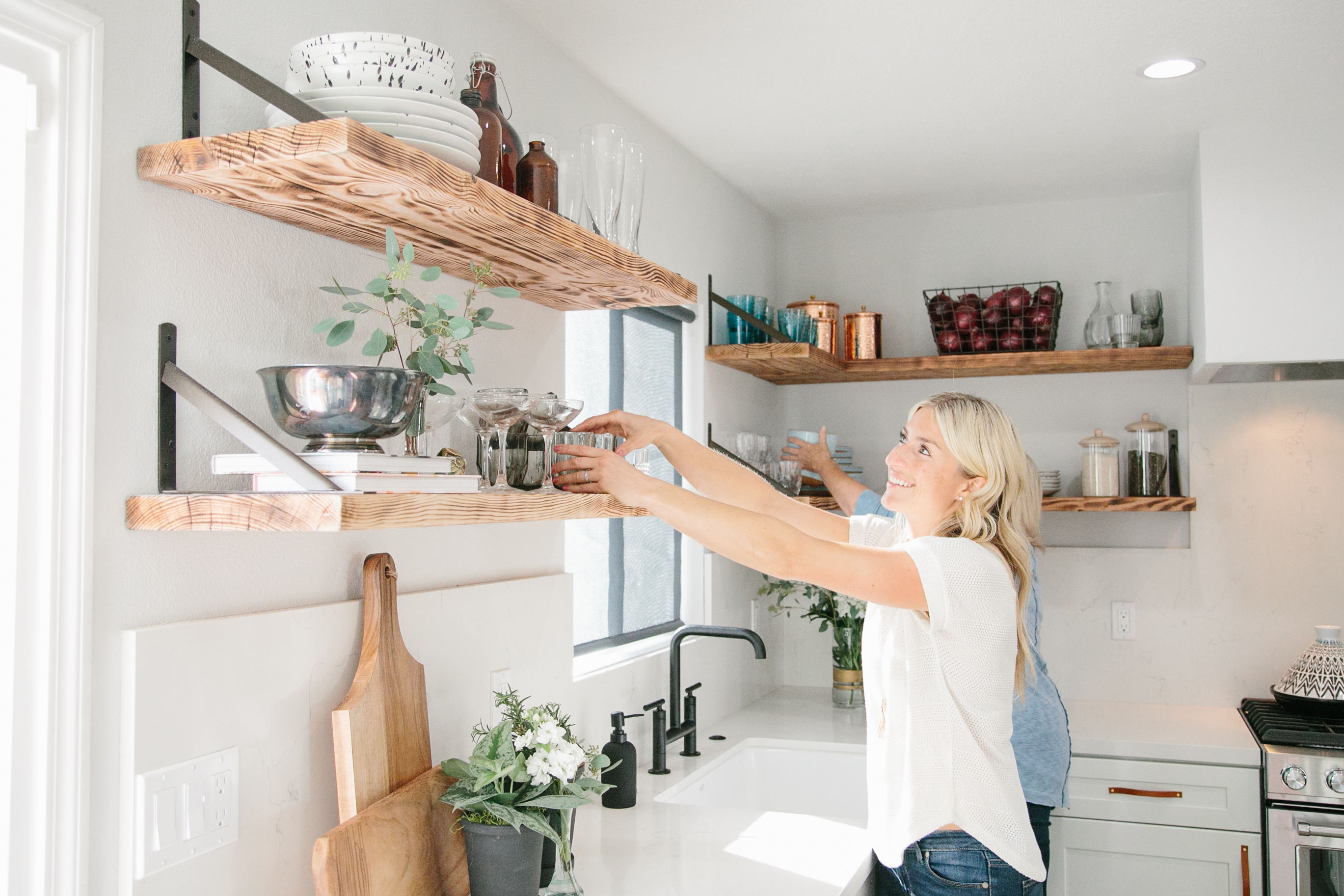 Jasmine (Host) adds glass ware and simple colors in the kitchen to help offset the all of the modern and sleek white.