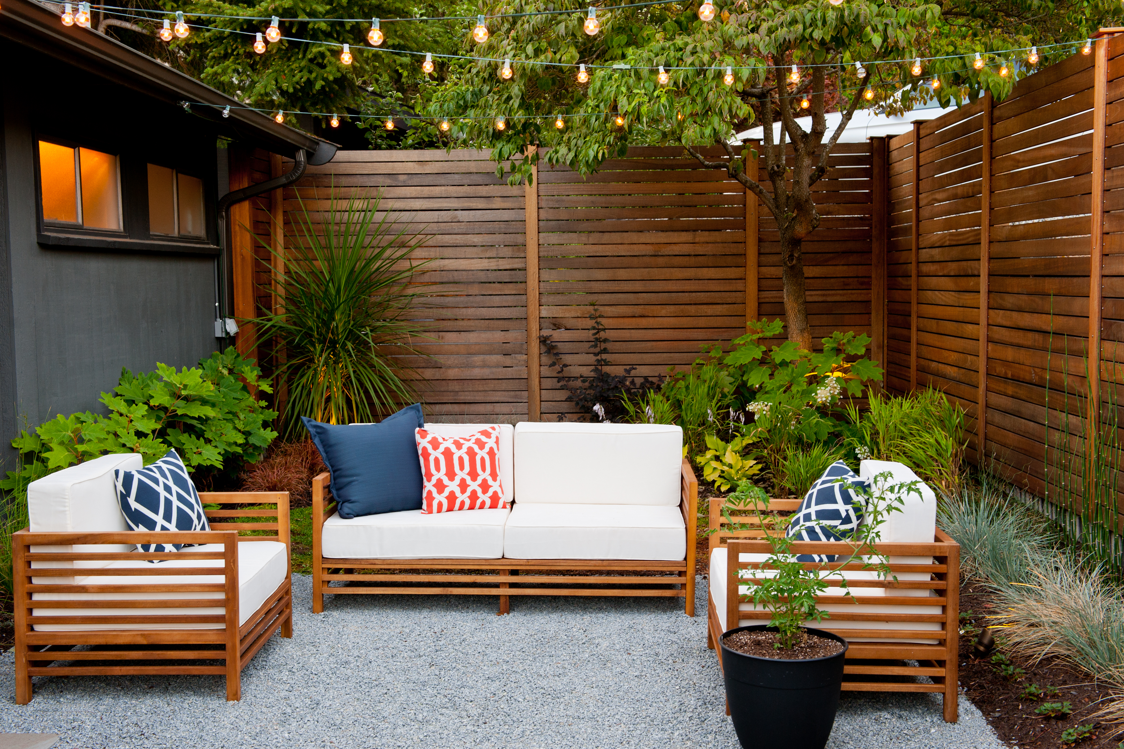 The asphalt paving at the front door of our client's new house was a bit of an eyesore and had been used by previous owners as an RV parking space.  Already partially enclosed by a fence and concrete wall, our client had a vision of transforming the space into an outdoor courtyard for entertaining on warm summer evenings. He imagined the space with a lounge, lighting and paving surrounded by plants. 

With our marching orders in place, we drew up a schematic plan quickly and met to review two options for the space. These options quickly coalesced and combined into a single vision for the space. A thick, 60” tall concrete wall would enclose the opening to the street – creating privacy and security, and making a bold statement. We knew the gate had to be interesting enough to stand up to the large concrete walls on either side, so we designed and had custom fabricated by Dennis Schleder (www.dennisschleder.com) a beautiful, visually dynamic, self-latching metal gate. The gate has become the icing on the cake, all 300 pounds of it!

Other touches include drought tolerant planting, bluestone paving with pebble accents, crushed granite paving, LED accent lighting, and outdoor furniture. Both existing trees were retained and are thriving with their new soil. The garden was installed in December 2014 and our client is extremely happy with the results – so are we!