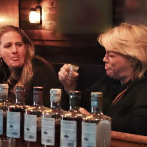 Janelle grimaces after drinking her first-ever shot, as David and Christine look on.